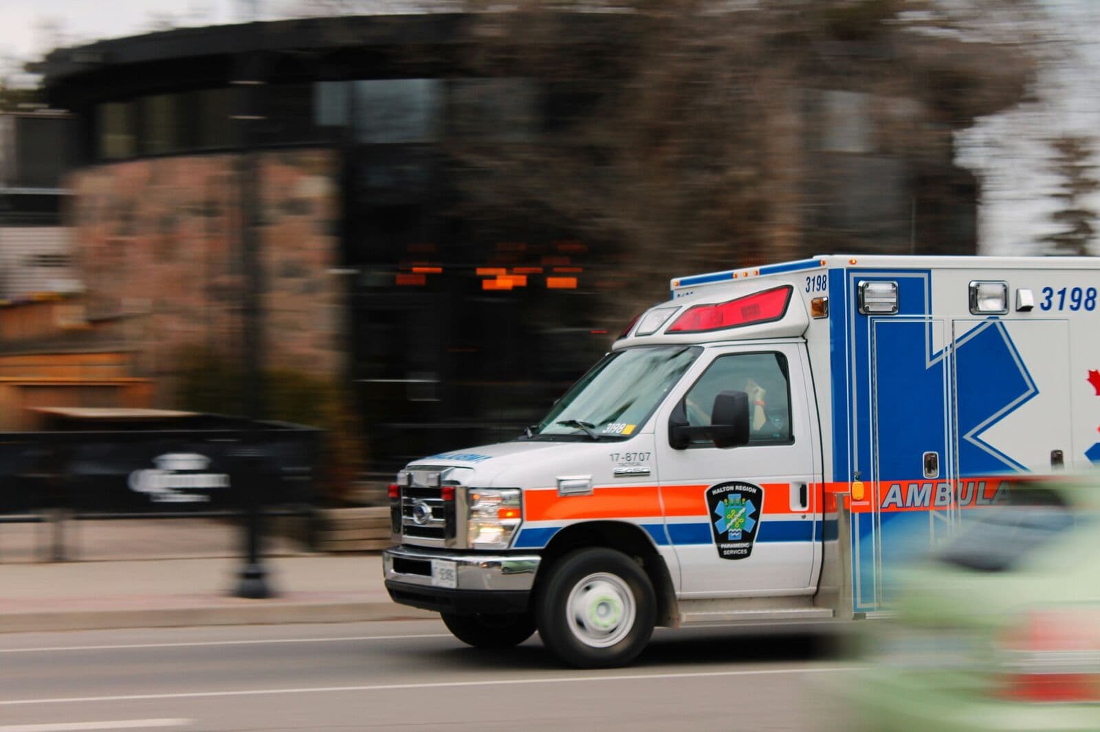 Krankenwagen fährt in Bewegungsunschärfe eine Straße entlang
